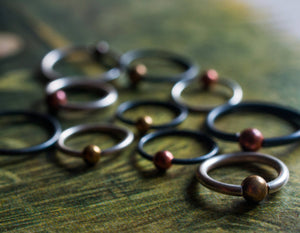 PIERCING RING WITH COPPER OR BRASS BALL
